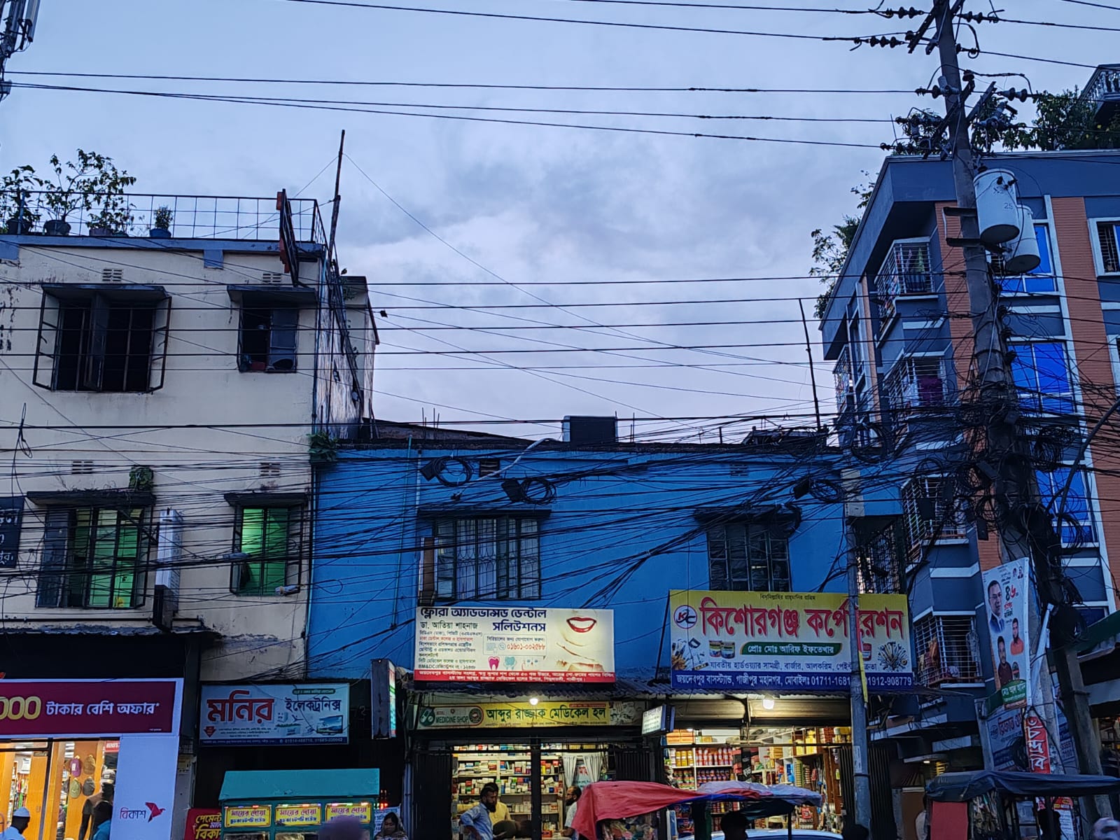 ফ্লোরা অ্যাডভান্সড ডেন্টাল সলিউশনস — সন্ধ্যায় দূর থেকে — নীল বিল্ডিংটি চিনে নিন